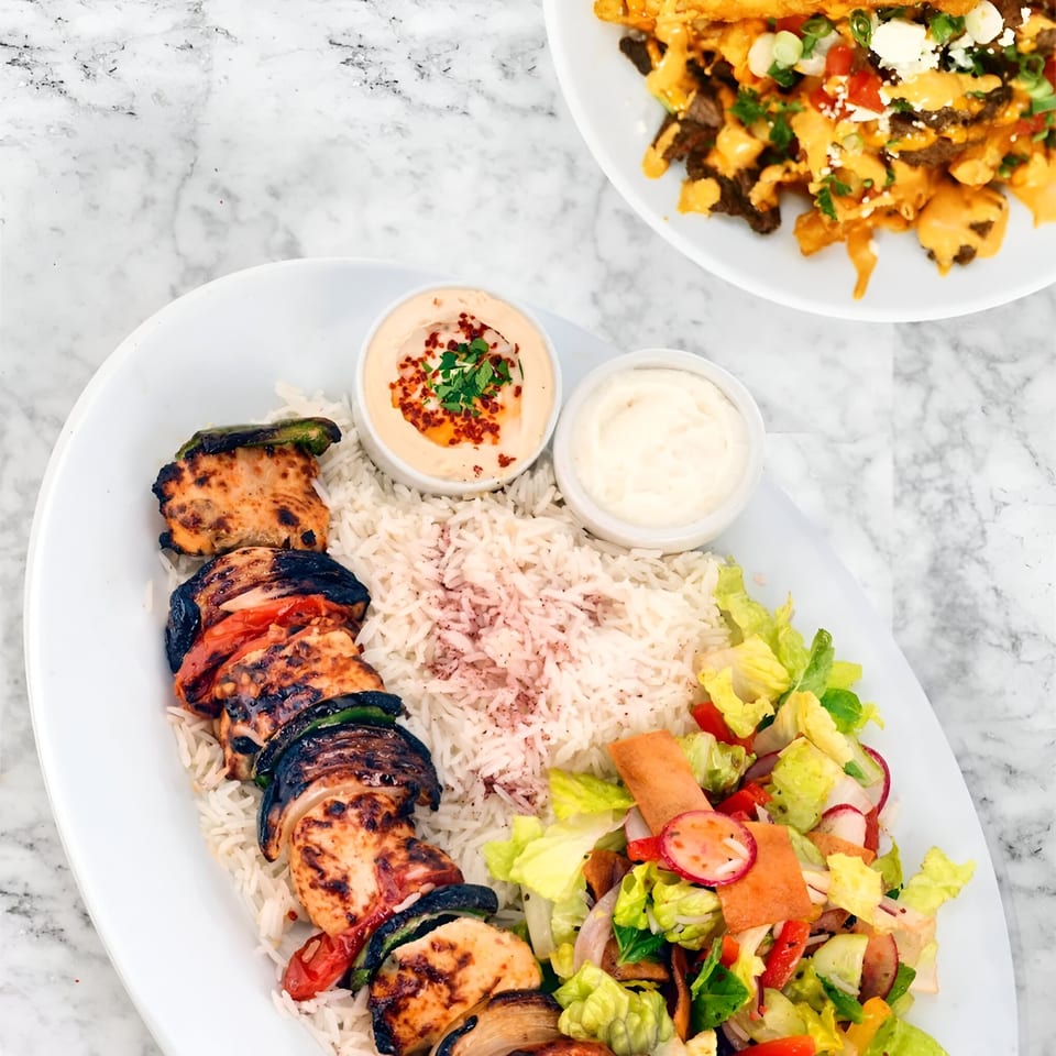 Tarme Mediterranean Grill's chicken shish tawook with rice, salad, hummus, and garlic sauce.