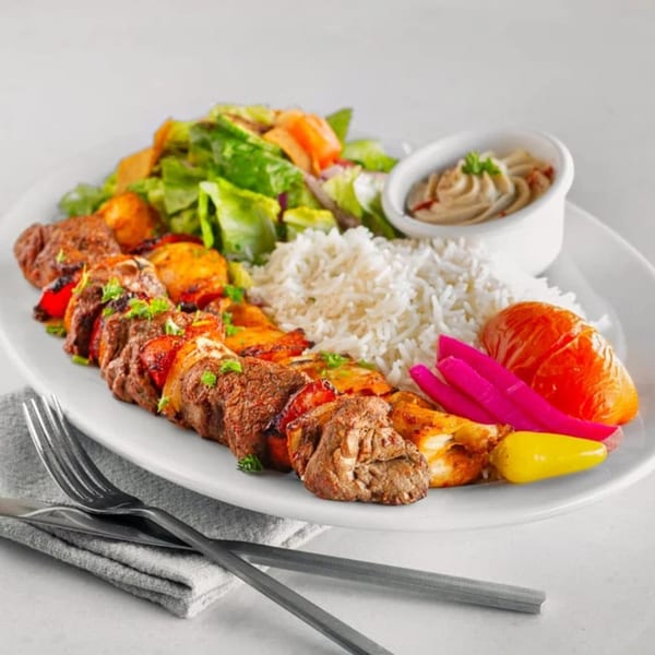 Tarme Mediterranean Grill's platter with beef and chicken kebabs, rice, salad, hummus, and pickled vegetables.